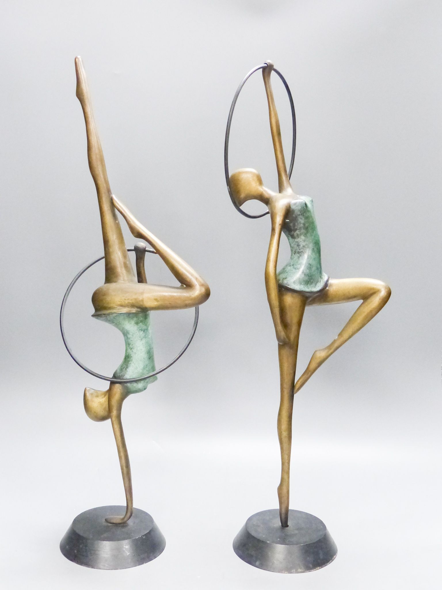 A pair of Hagenauer style bronze figures of hoop dancers, 51.5cm high